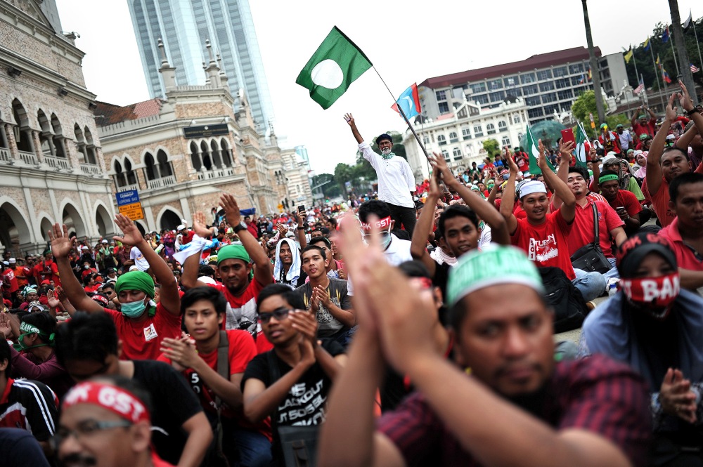 KUALA LUMPUR , 1/5/2014.Protesters greets while Malaysian Oppostion leader , Anwar Ibrahim start his speech infront od Sultan Abdul Samad Kuala Lumpur during May Day protest .Malaysia's opposition and activists demonstrate on May Day, also known as Labour Day, against the rising cost of living due to reduced subsidies and increased taxes.AWANI / SHAHIR OMAR